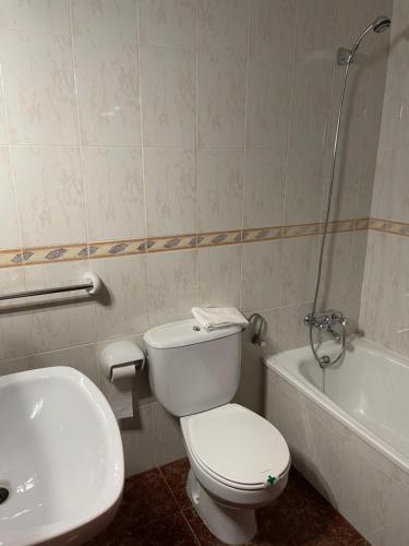 y baño con aseo, lavabo y bañera. en Hostal Parapanda, en Granada