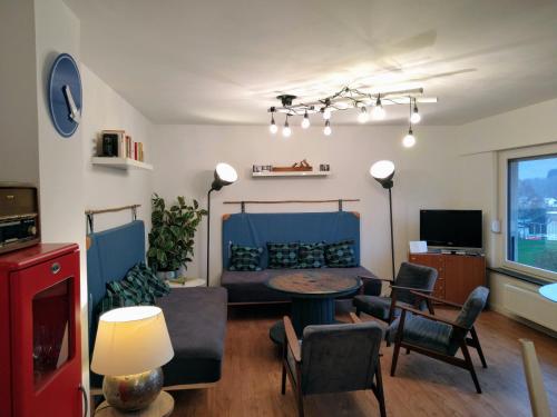 uma sala de estar com um sofá, uma mesa e cadeiras em Ferienhaus Fräulein Frenz em Bollendorf