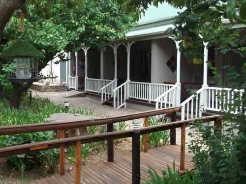 a porch of a house with a wooden deck at HouseMartin Lodge & Self Catering in De Rust