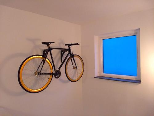 Una bicicleta colgada en una pared junto a una ventana en Ferienhaus Fräulein Frenz en Bollendorf