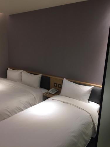 two beds sitting next to each other in a room at Michi Hotel - Zhongli in Zhongli
