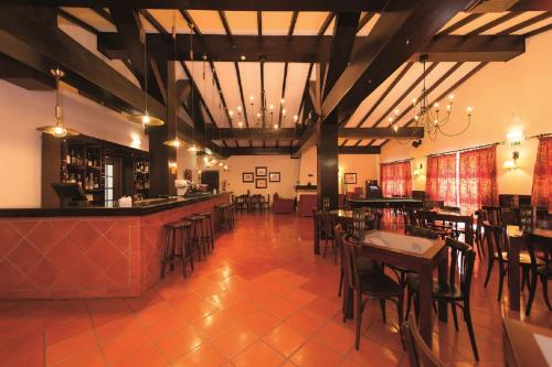 a restaurant with a bar and tables and chairs at Vila Gale Alentejo Vineyard - Clube de Campo in Albernoa