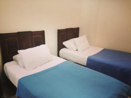 two beds sitting next to each other in a room at Borg Barka - Families Only in Alexandria