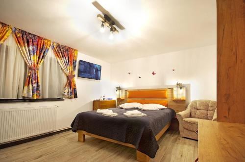 Un dormitorio con una cama y una silla dentro. en Apartament Diandru, en Slănic-Moldova
