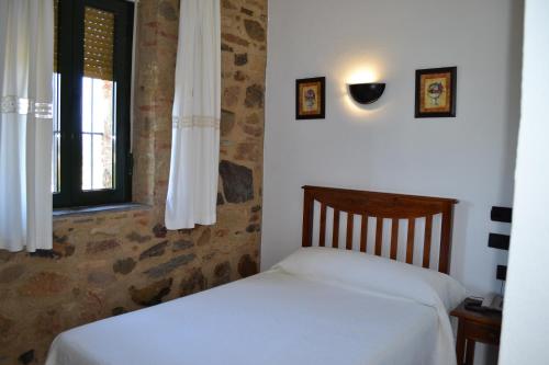 a bedroom with a bed and a window at Rincón del Abade in Encinasola