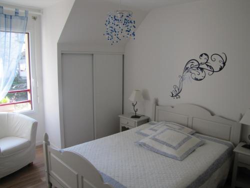 1 dormitorio blanco con 1 cama y 1 silla en Ker Marine, en Baden