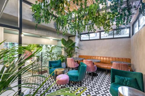 Dizengoff Garden Hotel في تل أبيب: مطعم فيه كراسي وطاولات ونباتات