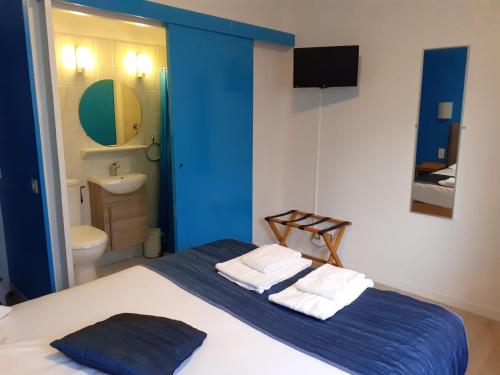 a blue and white bedroom with a bed and a bathroom at Hotel La Voilerie Cancale bord de mer in Cancale