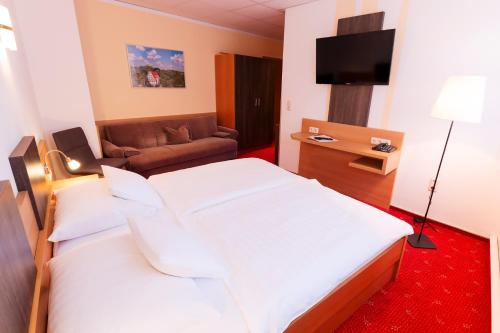 a hotel room with two beds and a couch at Hotel Pension Treppengasse Nr. 5 in Altenburg