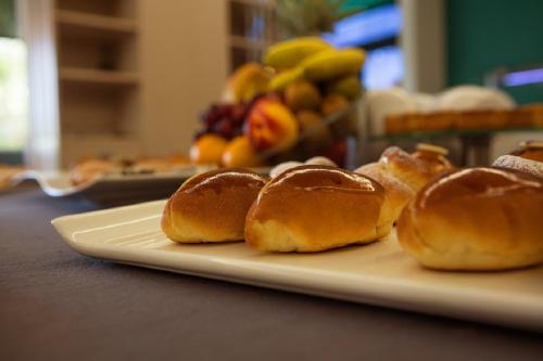 Un plato de panecillos sobre una mesa con fruta. en Hotel Escuela Santa Brígida, en Santa Brígida