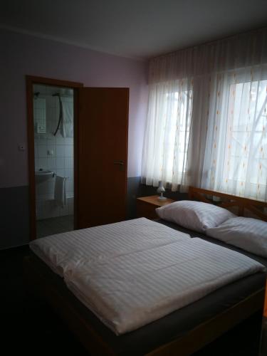 a bedroom with a bed and a bathroom with a shower at Pension Zum Angestellten in Porta Westfalica