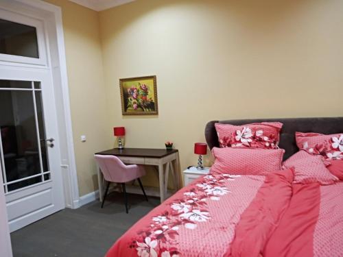 een slaapkamer met een bed met roze lakens en een tafel bij Villa Rosali Boutique Hotel in Hamburg