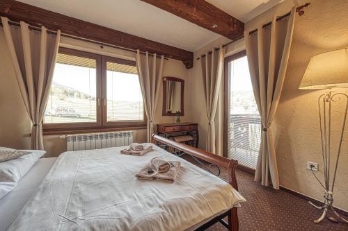 a bedroom with a bed and a large window at Penzion Katarina in Ždiar