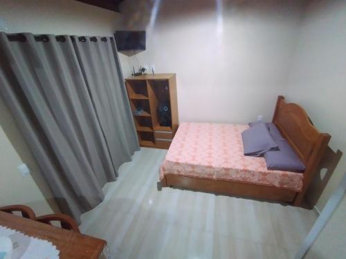 een kleine slaapkamer met een bed en een dressoir bij Residencial Pérola - Localizado entre a Pinheira e a Guarda do Embaú in Guarda do Embaú