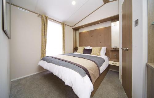 a bedroom with a large bed and a window at Lavender Lodge in South Cerney