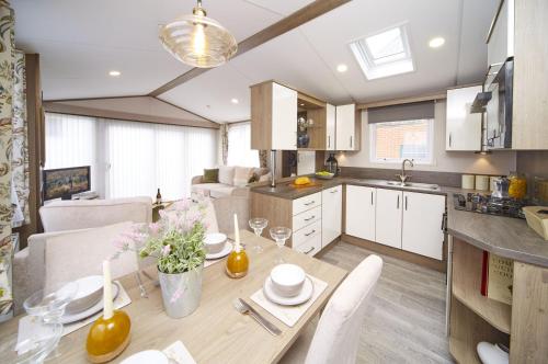 a kitchen and dining room with a table and chairs at Lavender Lodge in South Cerney