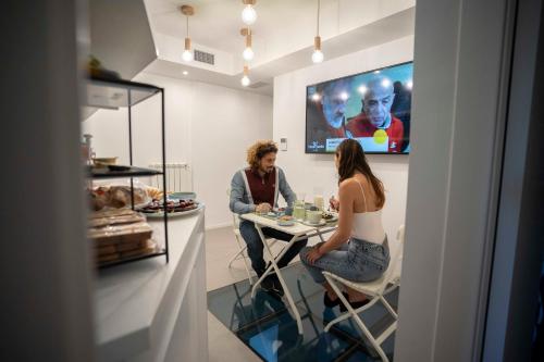 a man and woman sitting at a table in a room at NelBlu in Polignano a Mare