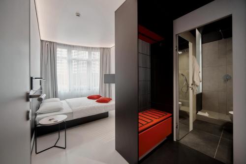 ein Schlafzimmer mit einem Bett und ein Badezimmer mit einer Dusche in der Unterkunft Atmosfera Hotel in Odessa