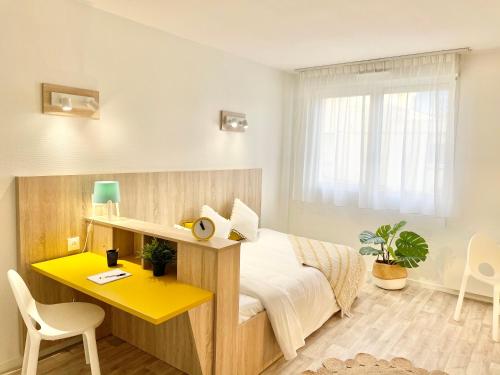 1 dormitorio con cama y escritorio amarillo en Sweetly Bordeaux Saint-Augustin, en Burdeos