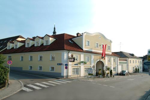 a large white building with a red roof on a street at Hotel Biedermeier Hof in Schärding