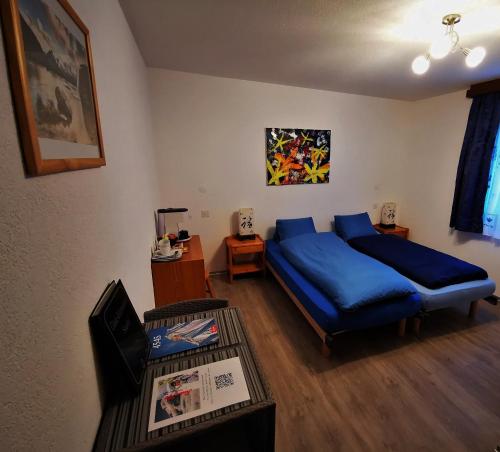 a living room with a blue bed and a table at Sunshine in Saas-Grund
