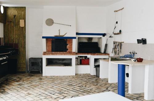 a kitchen with white cabinets and a fireplace at casa litoral in Pataias
