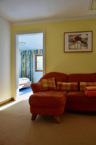 a living room with a red couch and a window at Haus Garber in Zell am Ziller