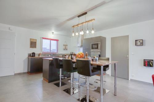 une cuisine et une salle à manger avec une table et des chaises dans l'établissement La Coralienne, à Plurien