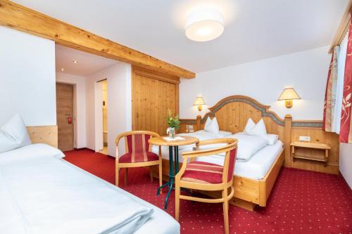 a hotel room with two beds and a table at Frühstückspension Klinglhub in Flachau