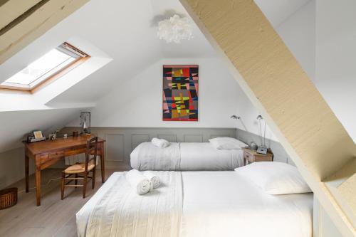 Schlafzimmer im Dachgeschoss mit 2 Betten und einem Schreibtisch in der Unterkunft Sotto Le Stelle - Fabuleux duplex d'hyper centre in Rennes