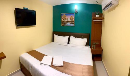a bedroom with a bed with two towels on it at Hotel Selesa in Sungai Buluh