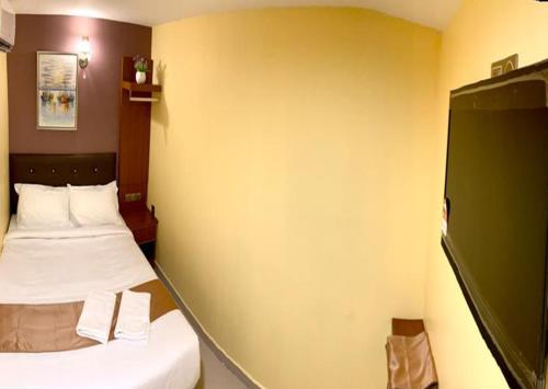 a small room with two beds and a green wall at Hotel Selesa in Sungai Buluh