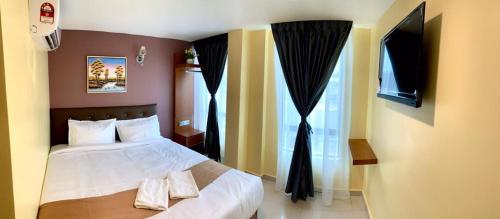 a bedroom with a bed with two towels on it at Hotel Selesa in Sungai Buluh