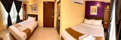 two beds in a hotel room with two bedsskirts at Hotel Selesa in Sungai Buluh