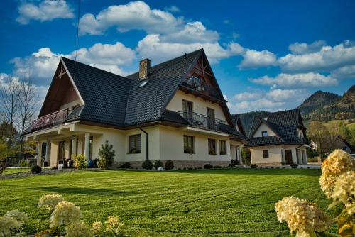 a house with a green lawn at Willa Magiera in Sromowce Niżne