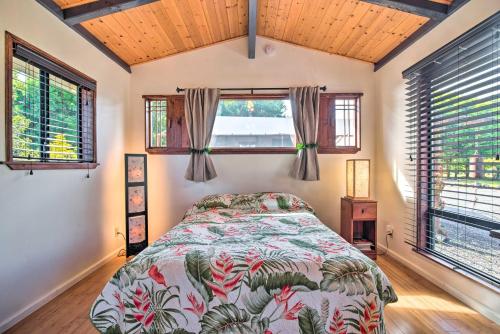 1 dormitorio con 1 cama y 2 ventanas en Cozy Volcano Studio with Phenomenal Rainforest Views!, en Mountain View
