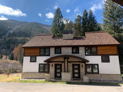 a house with a mountain in the background at Vail Racquet Club Mountain Resort in Vail