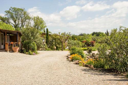 a garden with a gravel driveway and flowers at BUNGALOW 60 M2 in Roquebrune-sur-Argens