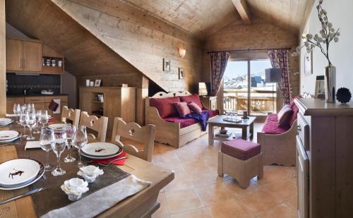 uma cozinha e sala de estar com mesa e cadeiras em CGH Résidences & Spas Le Chalet des Dolines em Montgenèvre