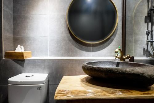 a bathroom with a sink and a mirror on the wall at 唯識禪居-訂房後需聯繫轉帳 in Tainan