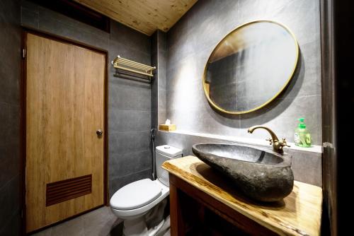 a bathroom with a sink and a mirror at 唯識禪居-訂房後需聯繫轉帳 in Tainan