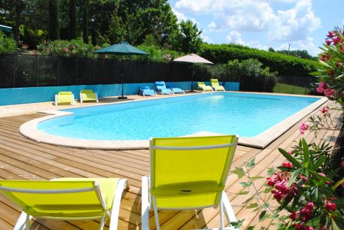 una piscina con 2 sillas y una piscina en Meric Gites, en Dolmayrac