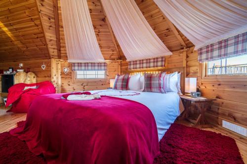 a bedroom with a large bed in a wooden room at Hatters Meadows Glamping in Ely