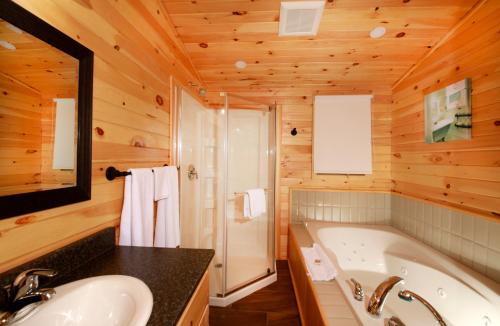 a bathroom with a tub and a sink at Cavendish Maples Cottages in Cavendish