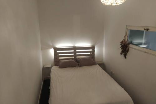 1 dormitorio pequeño con 1 cama en una habitación blanca en Appartement T2 cosy et chaleureux - 40mn de Rennes, en Plumaugat
