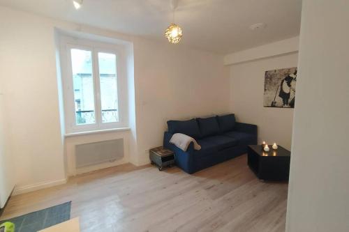 sala de estar con sofá azul y ventana en Appartement T2 cosy et chaleureux - 40mn de Rennes, en Plumaugat