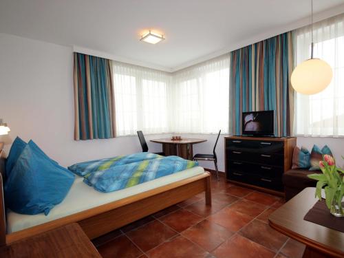 ein Schlafzimmer mit einem Bett und ein Wohnzimmer mit einem Tisch in der Unterkunft Apartments Schloß-Weißenstein-Straße in Matrei in Osttirol