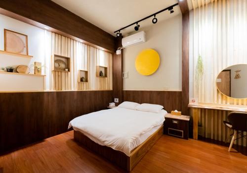a bedroom with a bed and a desk in it at 唯識禪居-訂房後需聯繫轉帳 in Tainan