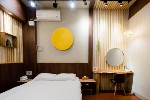 a bedroom with a bed and a yellow circle on the wall at 唯識禪居-訂房後需聯繫轉帳 in Tainan