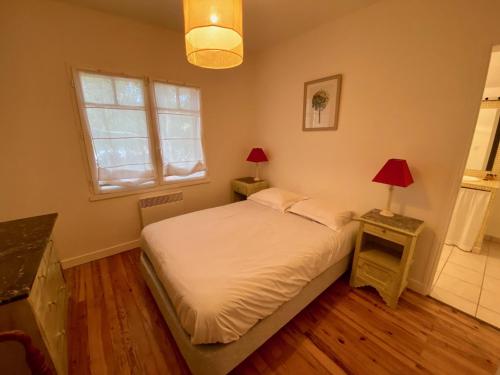 - une chambre avec un lit, une fenêtre et 2 lampes dans l'établissement Welcoming house in Cap Ferret close to the beach, Garden, Terrace, Wifi and TV, à Lège-Cap-Ferret